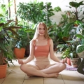 Adenium, kobieta medytująca wśród zieleni domowej